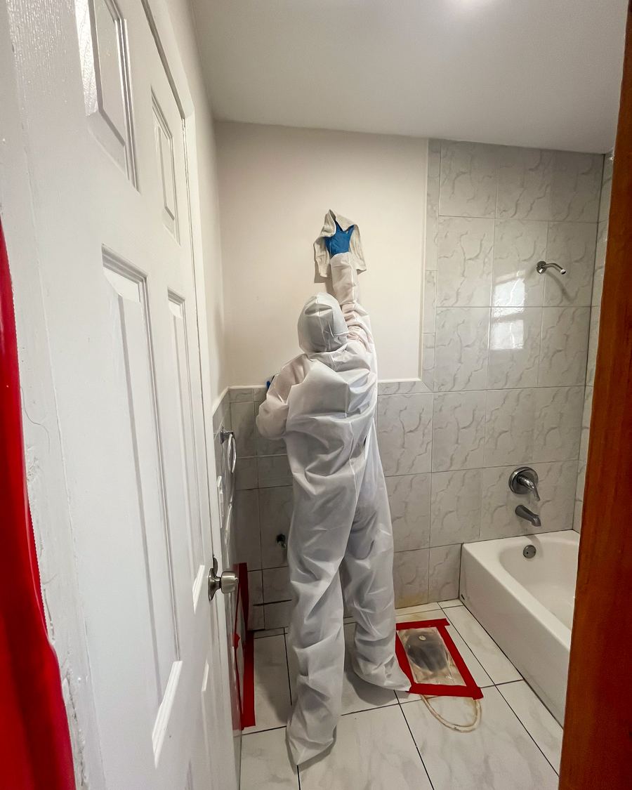 Specialist in protective suit working in a bathroom