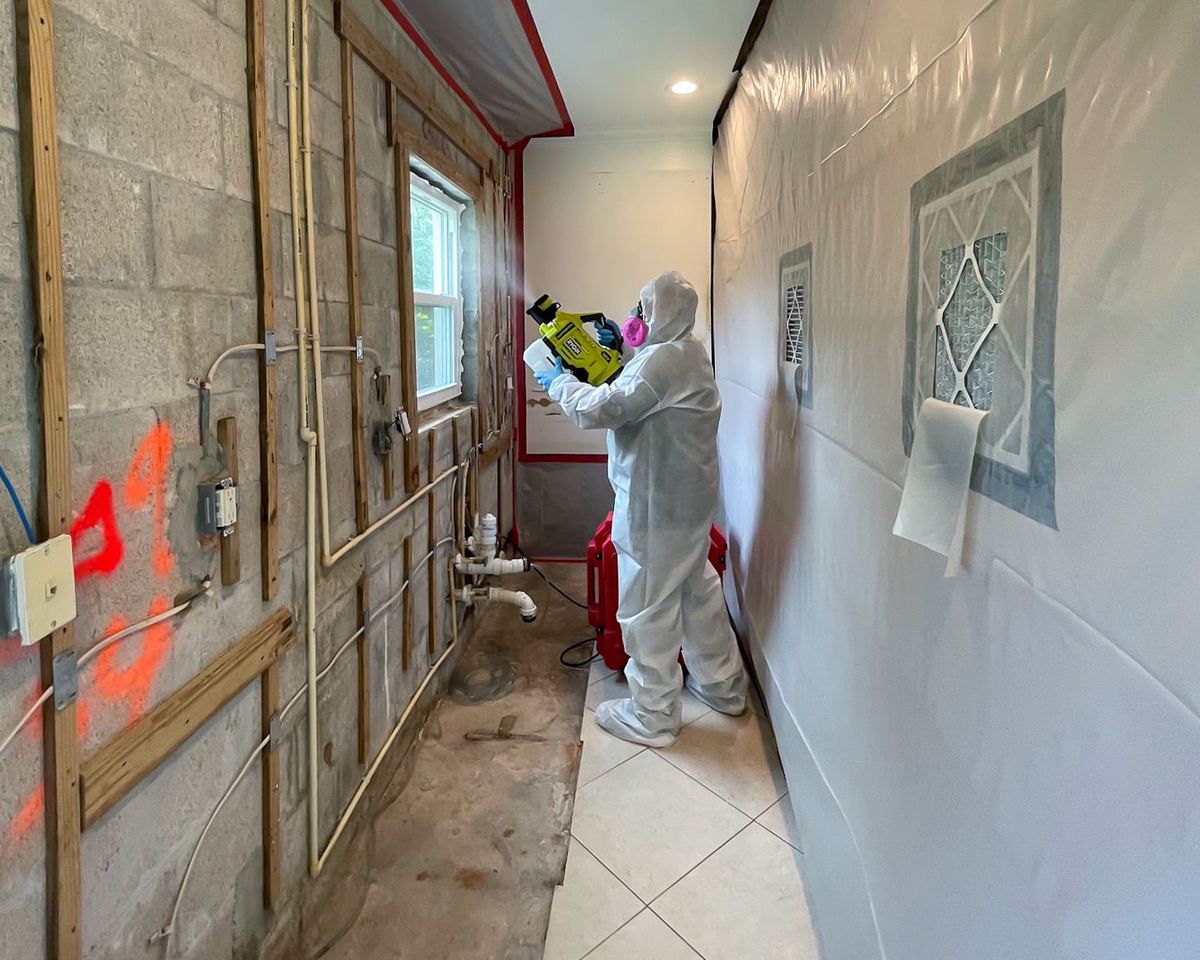 PPE specialist applying odor treatment inside containment zone