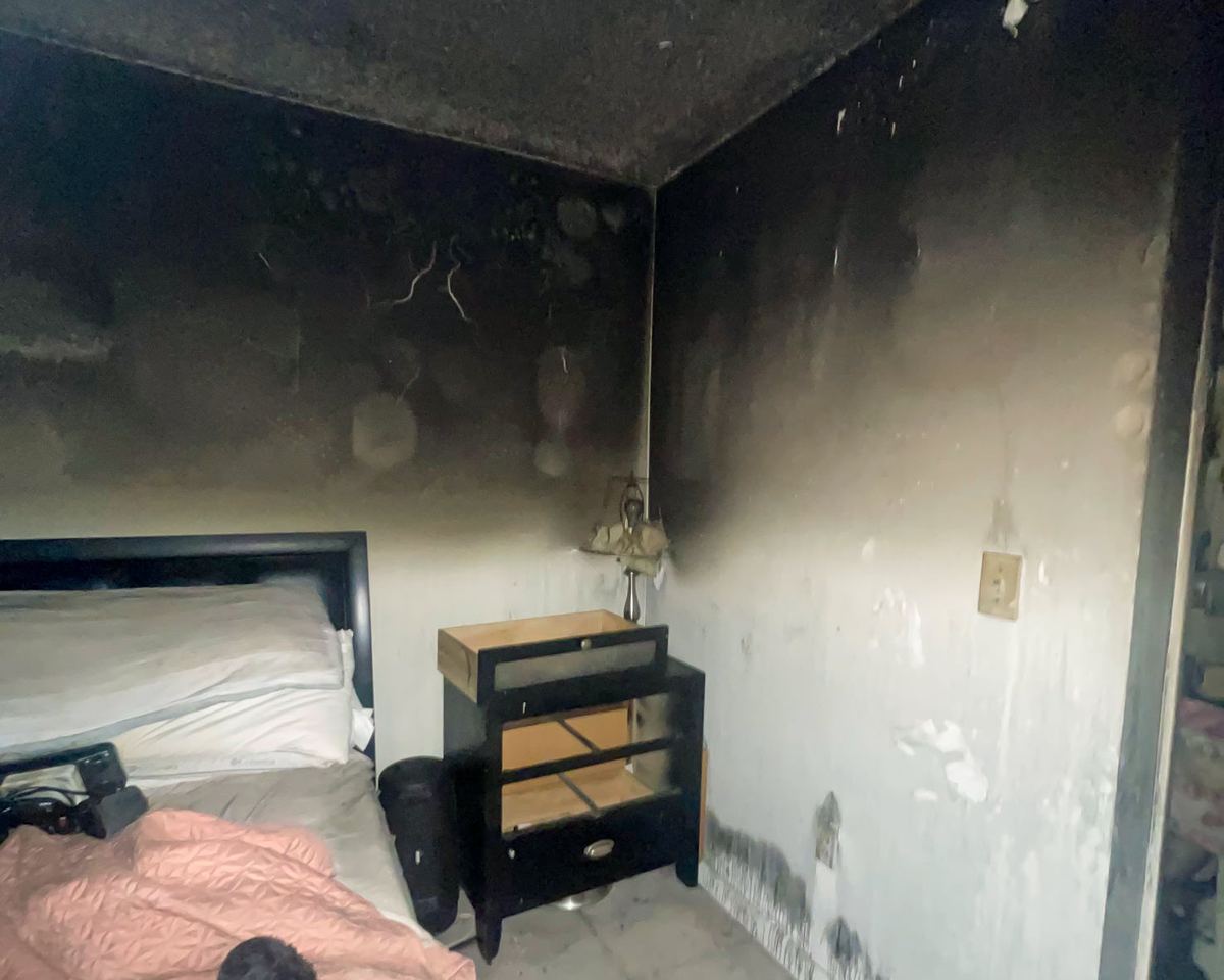 Smoke-damaged bedroom, soot on walls and ceiling