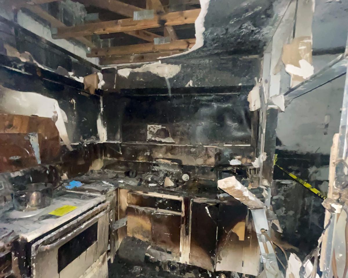 Fire-destroyed kitchen, complete soot damage, stove and cabinets burned