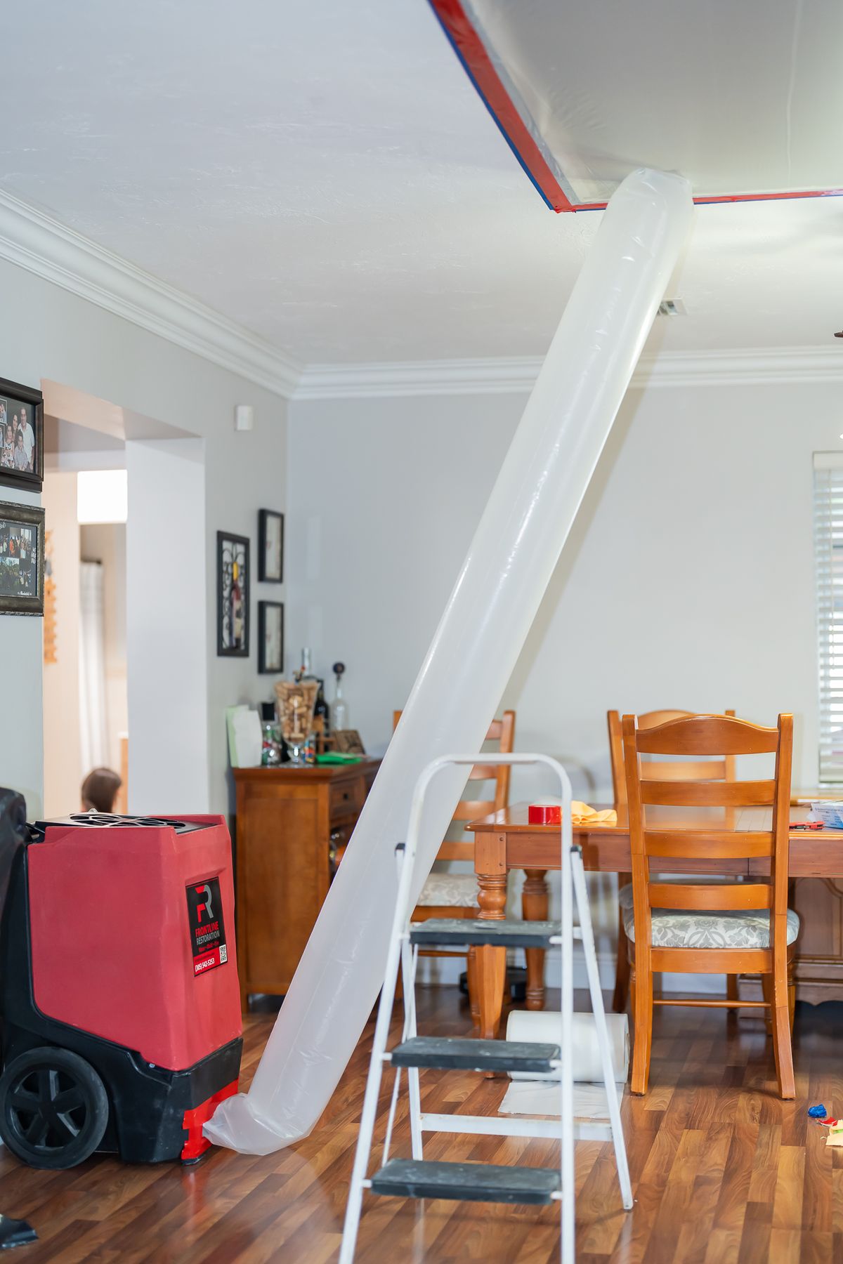 Plastic containment sheeting and a dehumidifier set up in a home