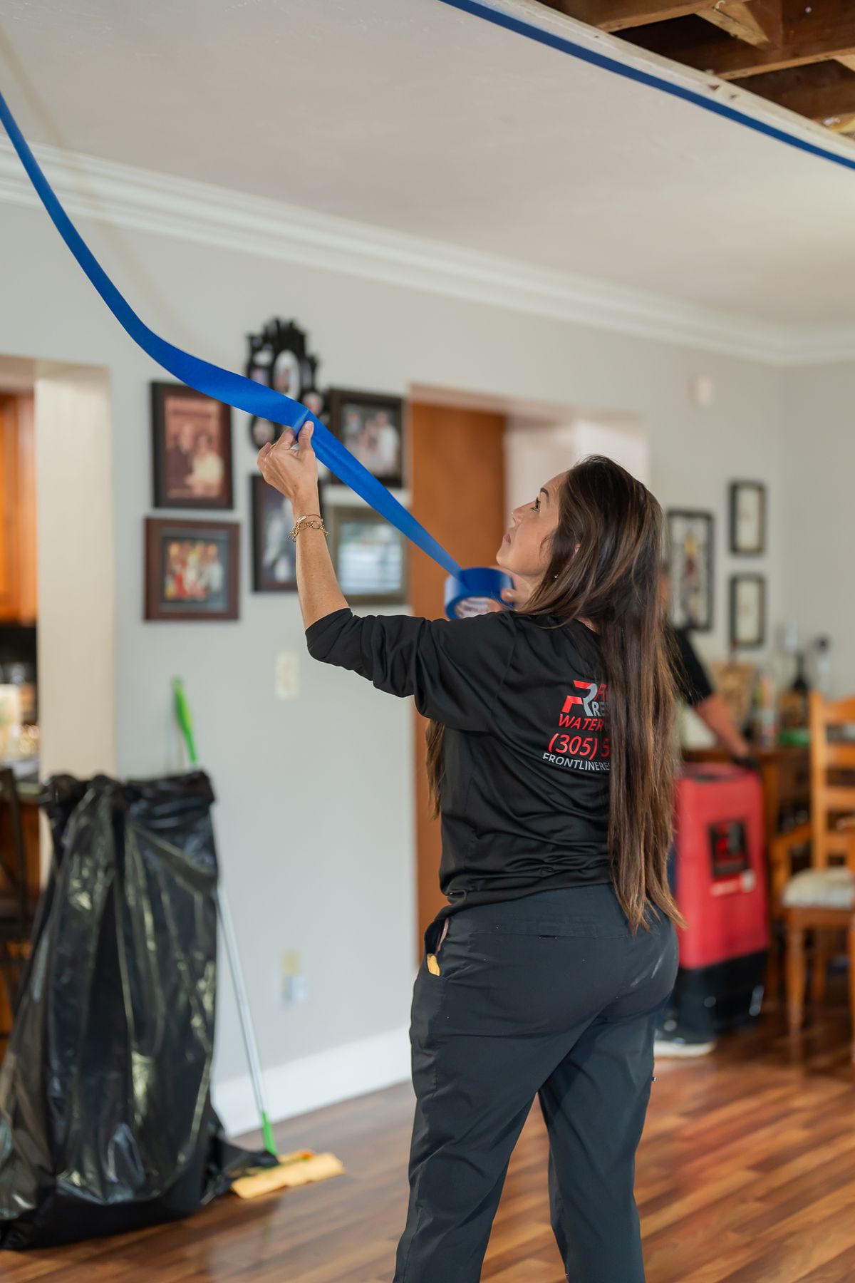 Technician sealing plastic containment sheeting during treatment