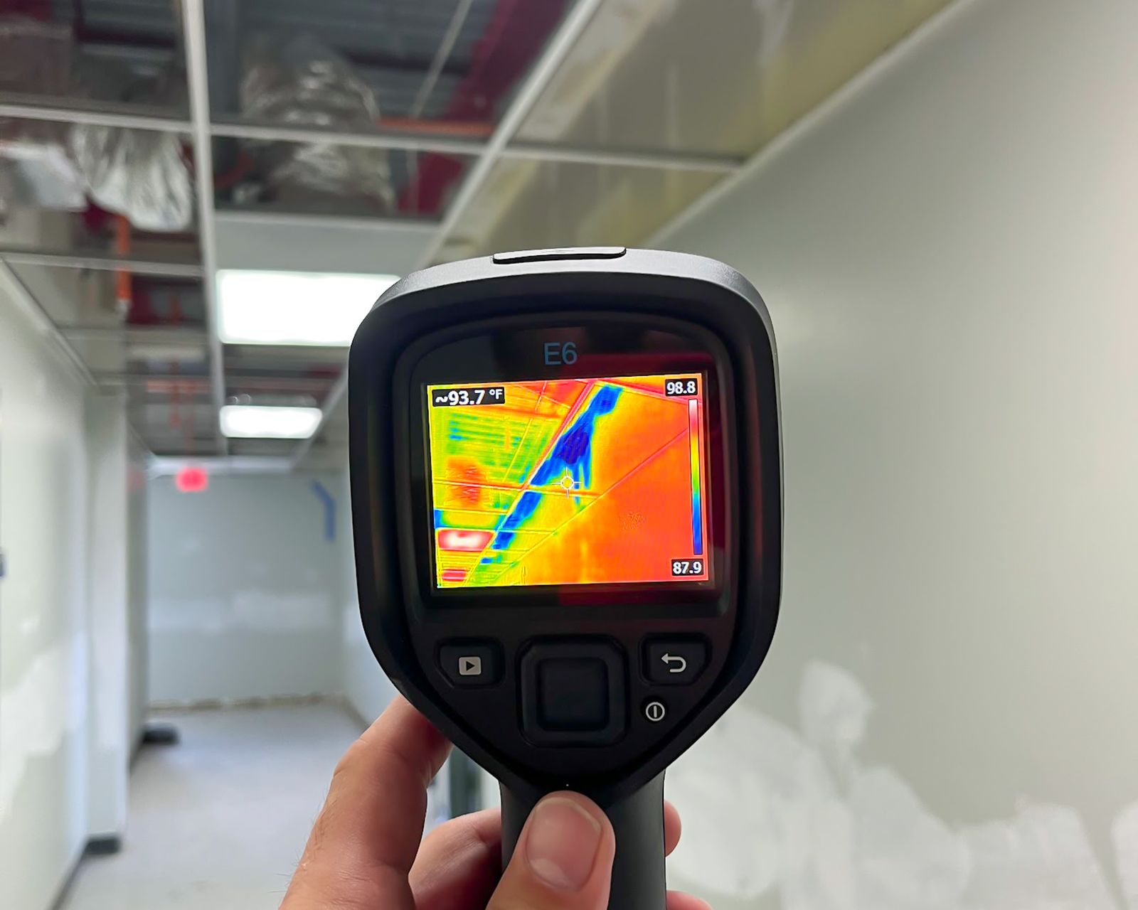 Thermal camera held up in a corridor to scan for hidden moisture