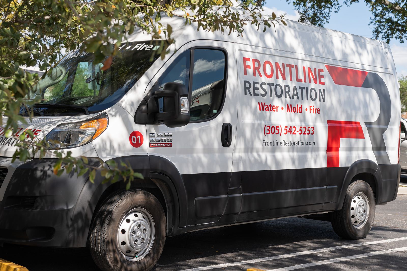 Frontline Restoration van parked outside a home beneath mature trees